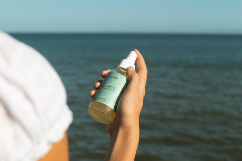 Woman holding wave spray with ocean in background