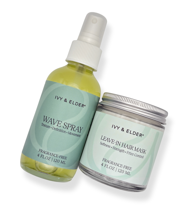 Two Ivy & Elder hair care products cut out: a Wave Spray bottle and a Leave-In Hair Mask jar. The Wave Spray bottle is translucent with a pale yellow liquid and a white spray top, while the Leave-In Hair Mask jar has a silver lid and a matching pale green label.